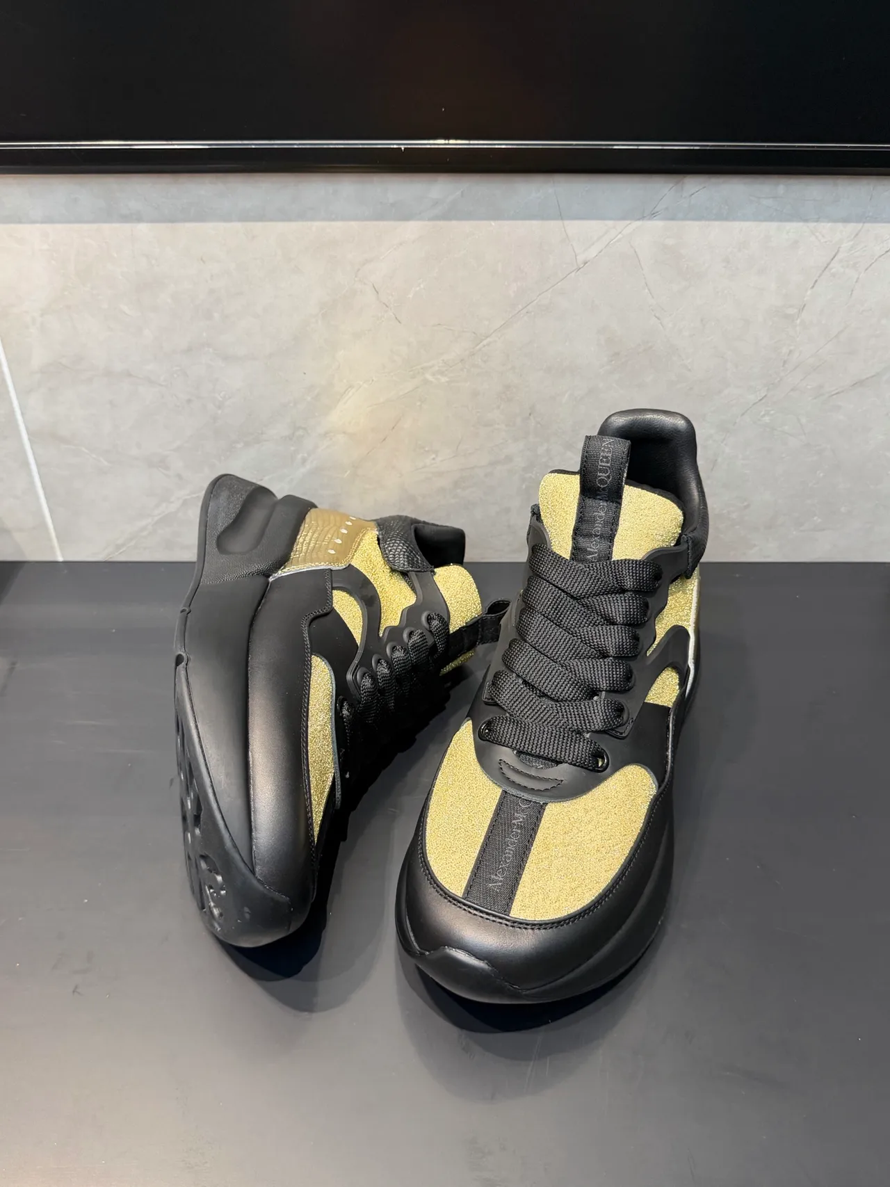 Alexander McQueen أحذية أسود ذهبي oversized silhouette لوحات لامعة chunky sneakers 3