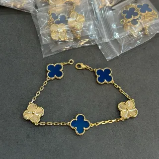 Pulseira de corrente dourada com charms em forma de trevo azul
