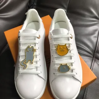 Tênis lifestyle com parte superior de couro liso branco e dourado, adornos de pin de gato esmalte