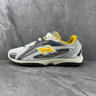 New Balance رمادي وأصفر طبقات صناعية وشبكة علوية علامة 'N' بارزة أحذية رياضية نمط حياة