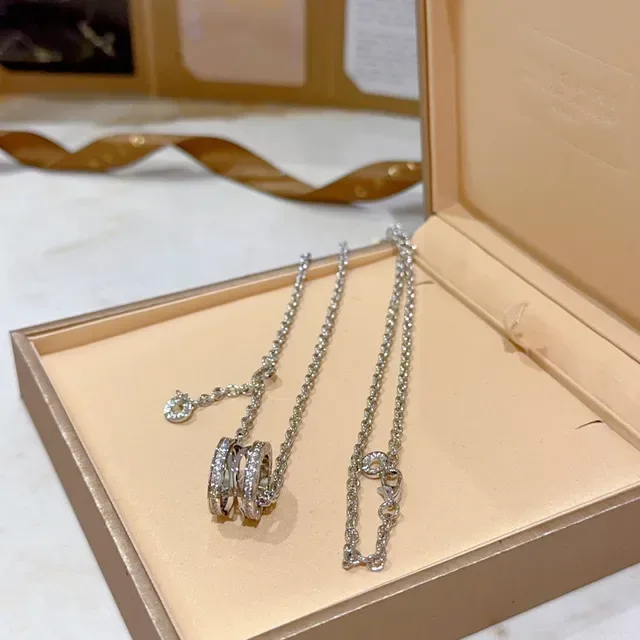 Bvlgari Collier argent et or avec pendentif rotatif à multiples anneaux et accents de diamants pavé 4