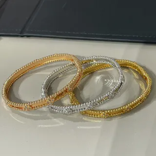 Pulseras bangle en tonos dorado y plateado con perlas pavé florales