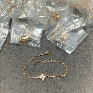 Pulsera de cadena de oro blanco con motivo floral de cuatro hojas