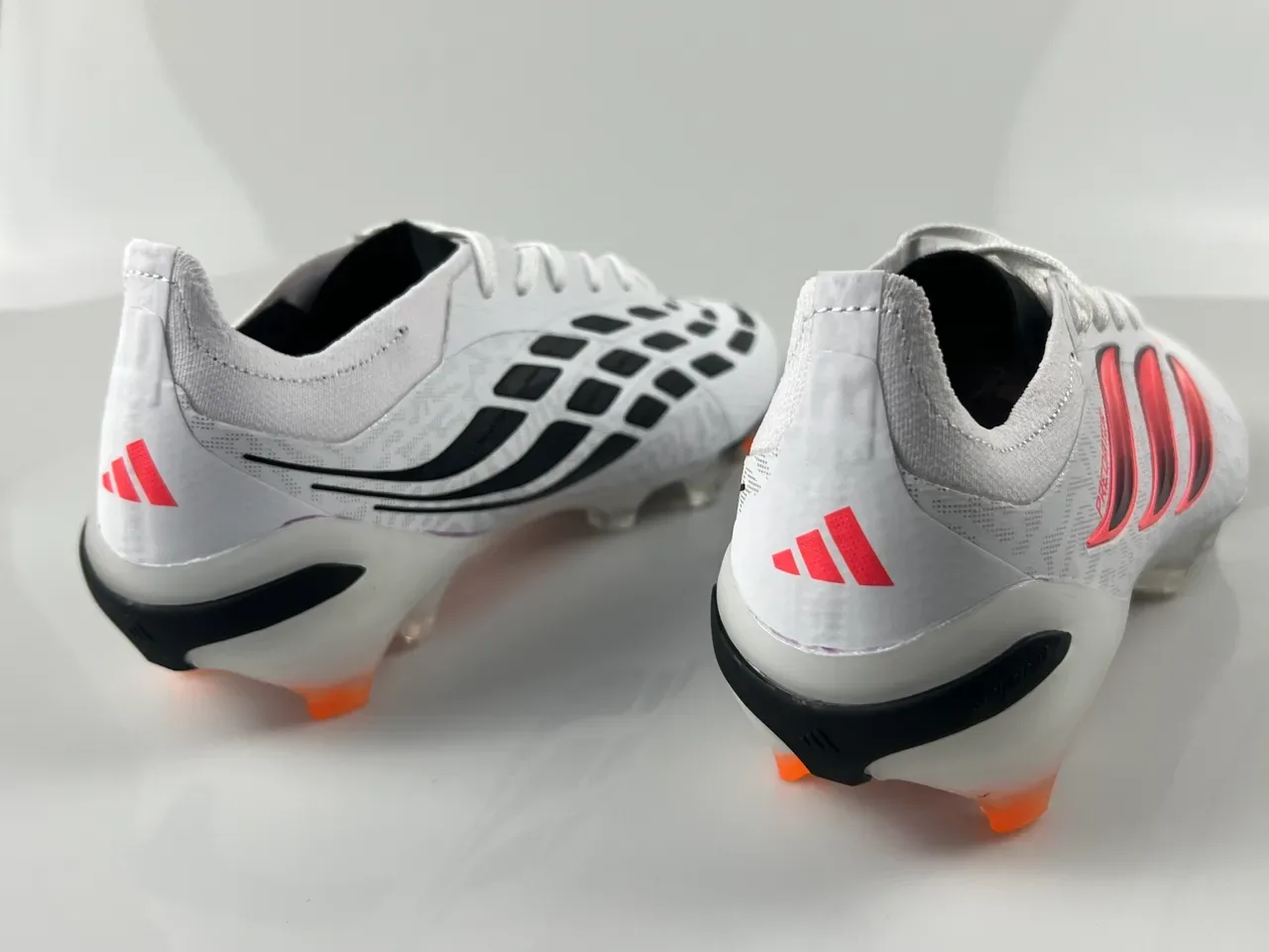 Adidas Predator Sapatos de futebol brancos e rosas de baixo corte com upper de malha degradável, três tiras, para terreno firme 9