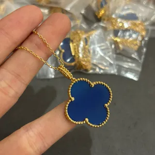 Colgante de forma de trébol azul y oro con detalle de borde perlado