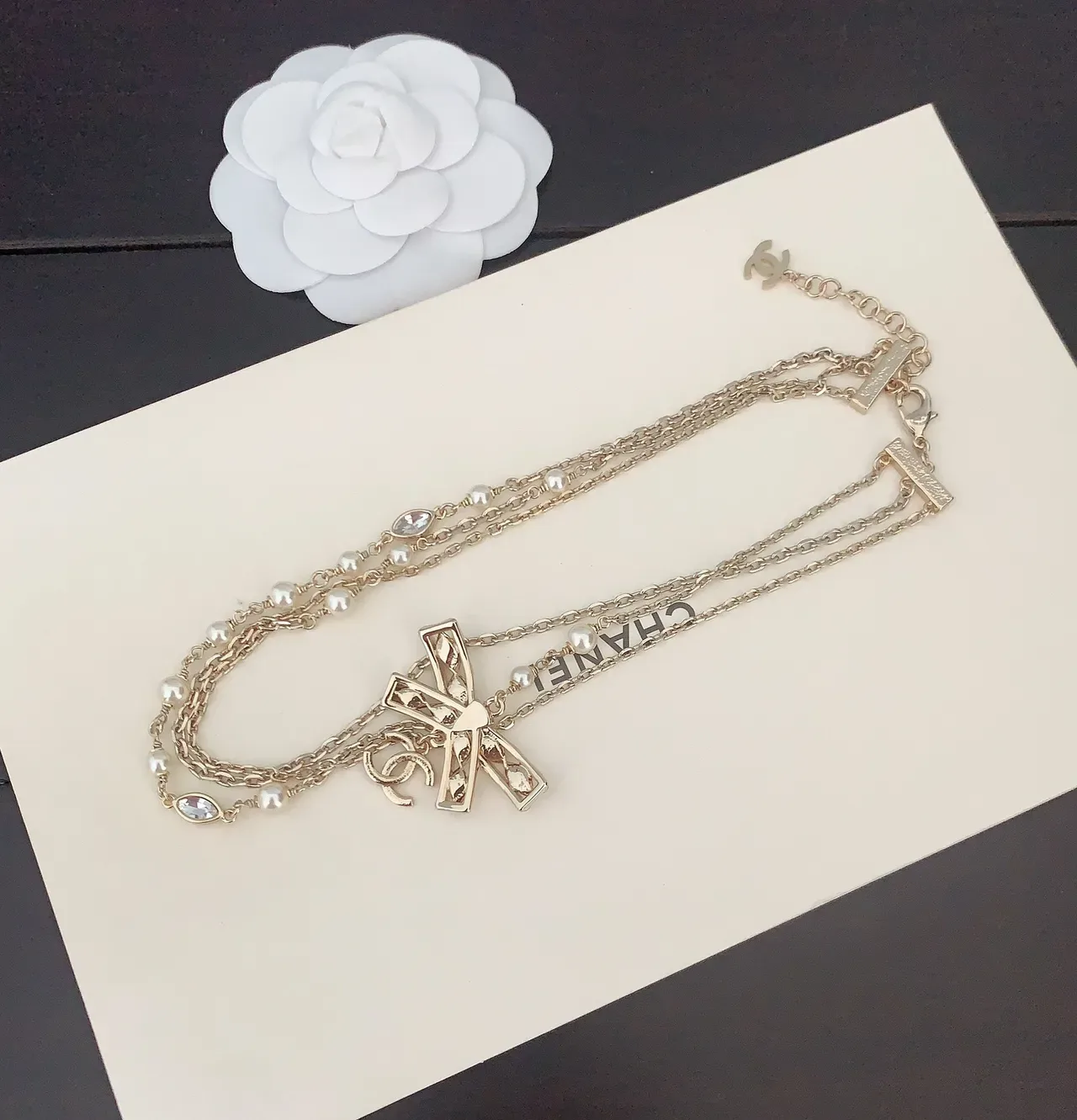 Collier Chanel chaîne multi-fils dorée blanche avec pendentif nœud orné de cristaux 2
