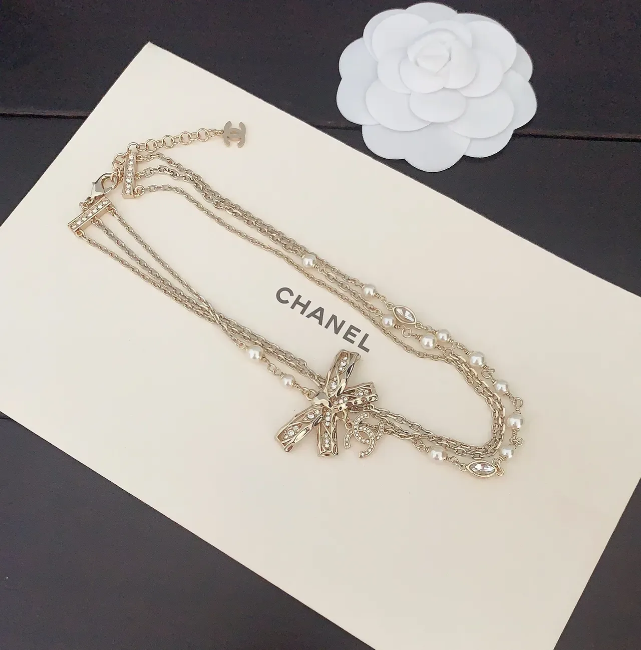 Collier Chanel chaîne multi-fils dorée blanche avec pendentif nœud orné de cristaux 3