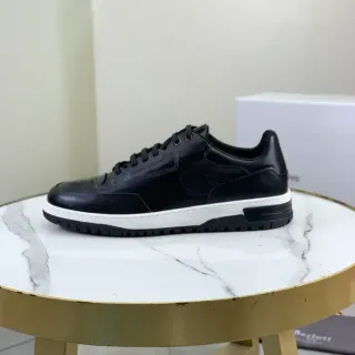 Zapatillas deportivas de cuero negro y blanco con perforación en la punta
