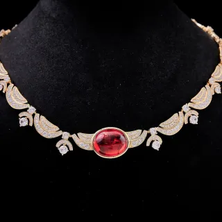 Collier ton doré ovale gemme rouge pavé motif d'aile