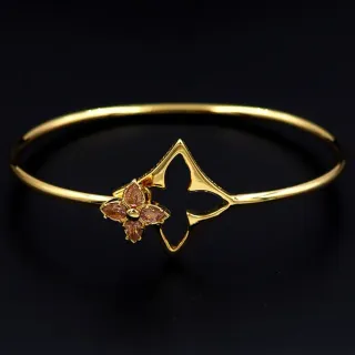 Brazalete de tono dorado con diseño cuádruple floral de gemas