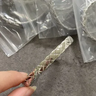 Bracelete prateado com padrão de diamante acolchado e torcido