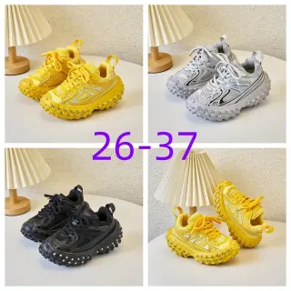 Tênis amarelo e prata com sola chunky, com tachas e sola com cravos