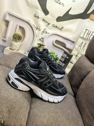 Adidas Chaussures de sport noires et blanches à semelle intermédiaire sculptée en couches de cage synthétique empilées avec semelle épaisse 9