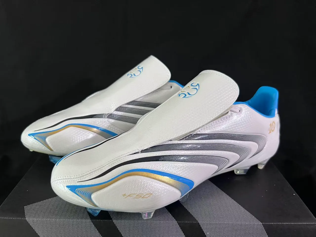 Adidas Chaussures de football blanc et bleu à col en chaussette, motif en vagues, trois bandes et surface ferme 10