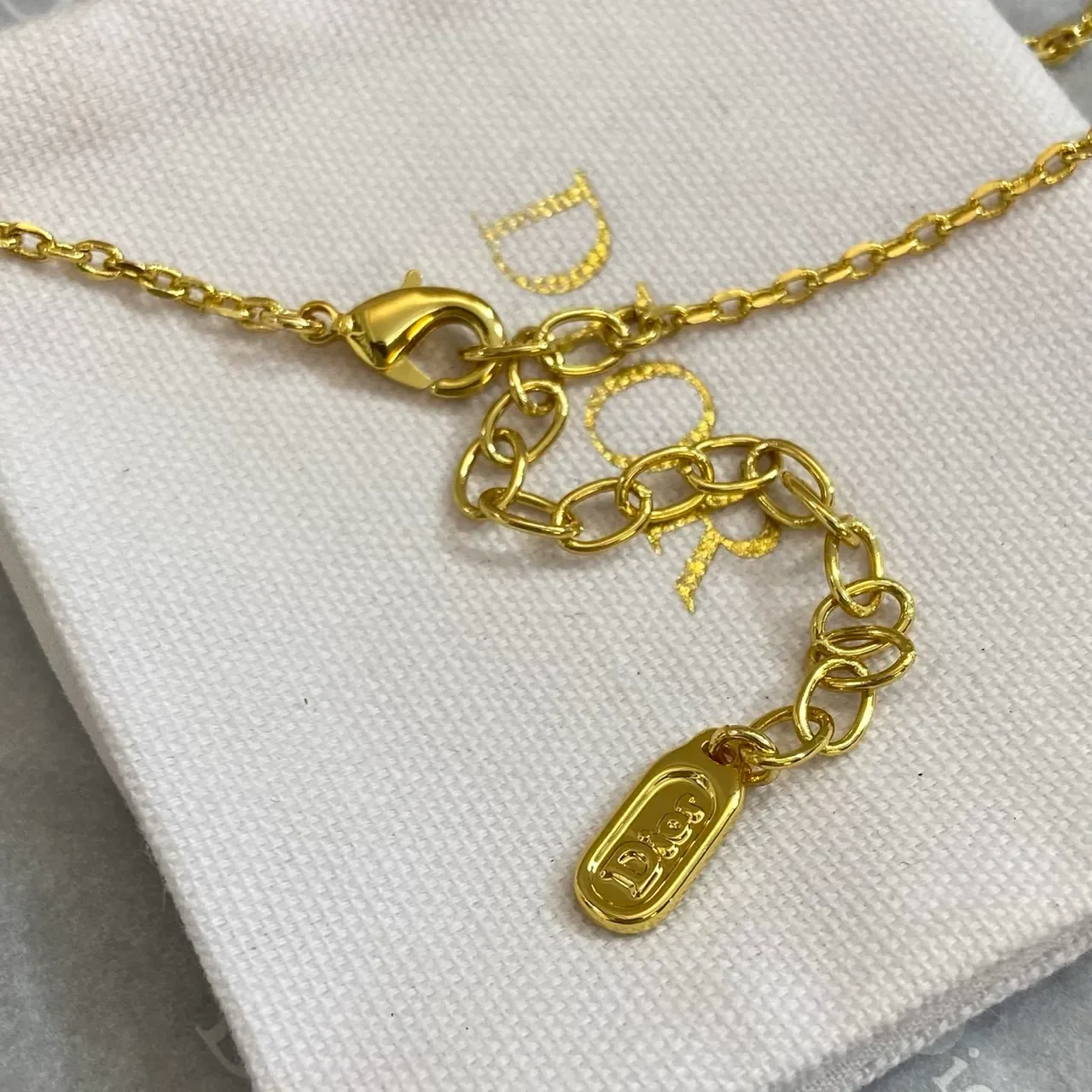 Collier pendentif nœud doré bleu gema goutte facettée de Dior 2