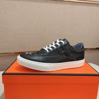 Sneakers pretas e brancas de couro no upper, com cadarços e sola