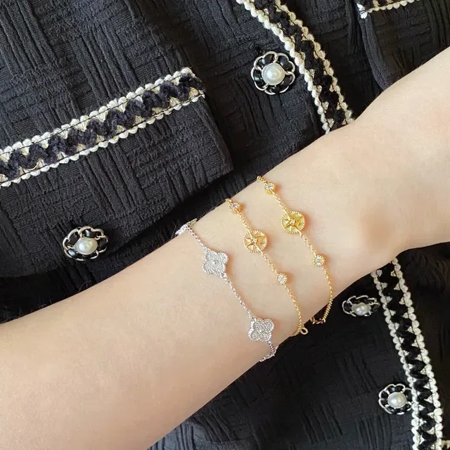 Braceletes de corrente em tom dourado com rosa do compasso em esmalte e cristal 9