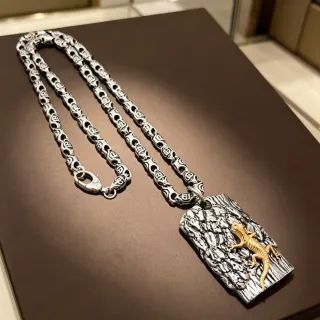 Collar con colgante de lagarto en plata y oro sobre corteza texturizada