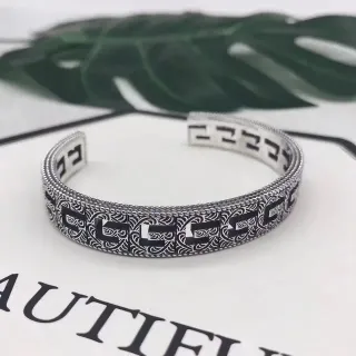 Pulsera plata y negro abierta grabada con patrón geométrico