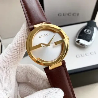 Gucci G-Timeless Interlocking G সোনালি টোনের সাদা ডায়াল সহ বাদামী চামড়ার স্ট্র্যাপের কোয়ার্টজ ওয়াচ