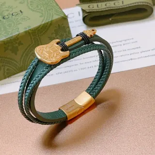 Gucci Pulsera de cuero trenzada con encanto de guitarra en verde y oro