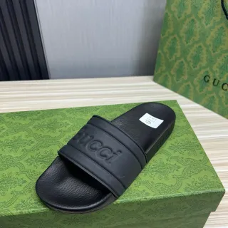 Gucci काले एम्बॉस्ड लोगो स्ट्रैप स्लाइड सैंडल