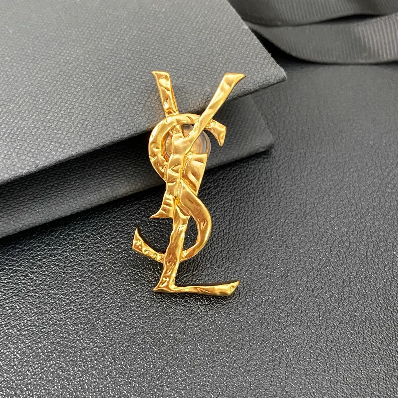 Saint Laurent بروش ذهبي أسود منحوتة حرف واحد ملتوية معدنية 9