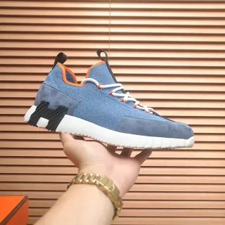 أحذية رياضية بيضاء بمخطط أزرق وبرتقالي، upper هجين من القطن المحبوك والسويد، sculpted ridged، midsole أبيض