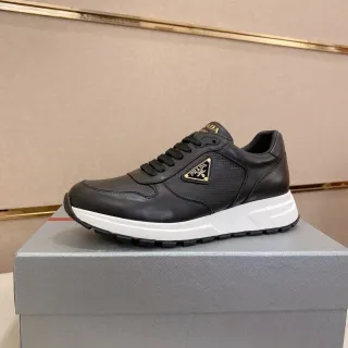 Prada Cloudbust أحذية رياضية أسود أبيض جلد ومثقوب علوي حافة ذهبية شعار مثلثي سميك