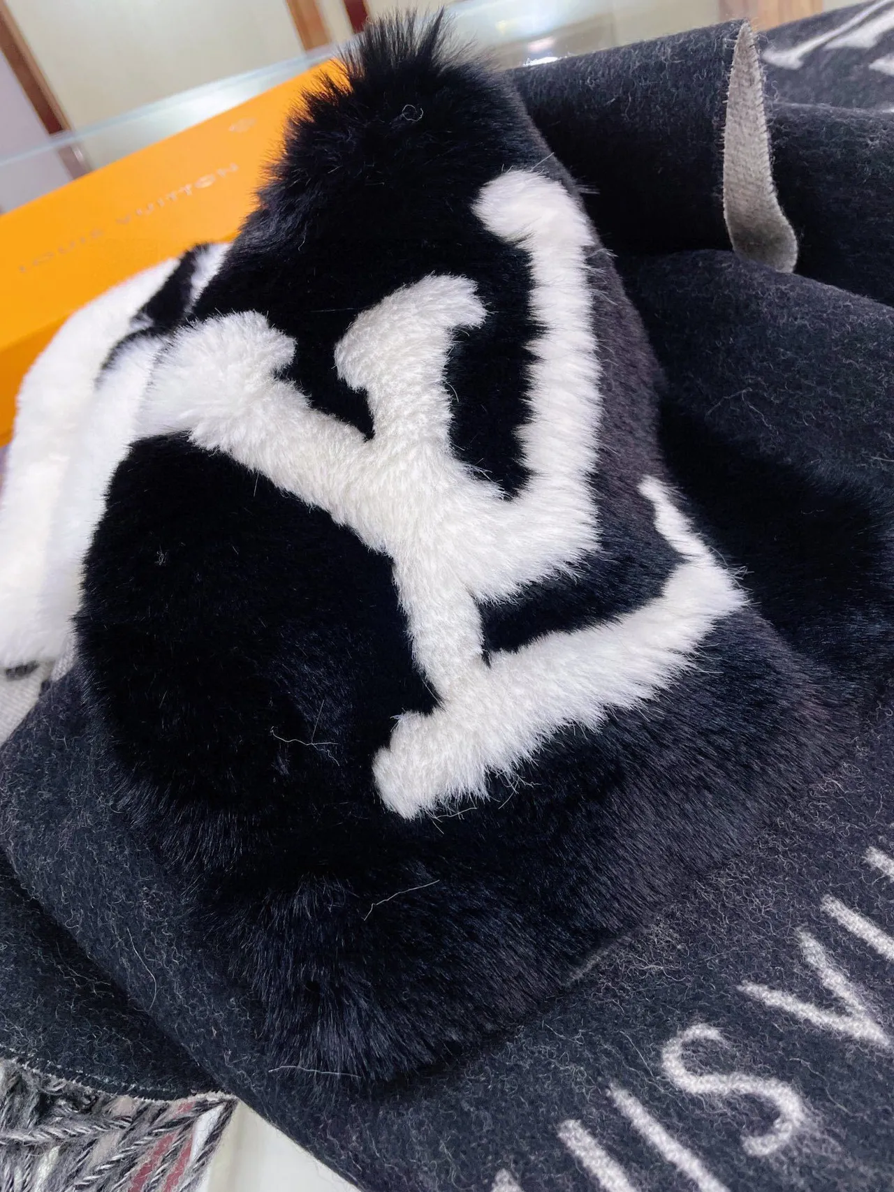 Écharpe au motif géométrique noir et blanc avec gros pompons en fausse fourrure 9
