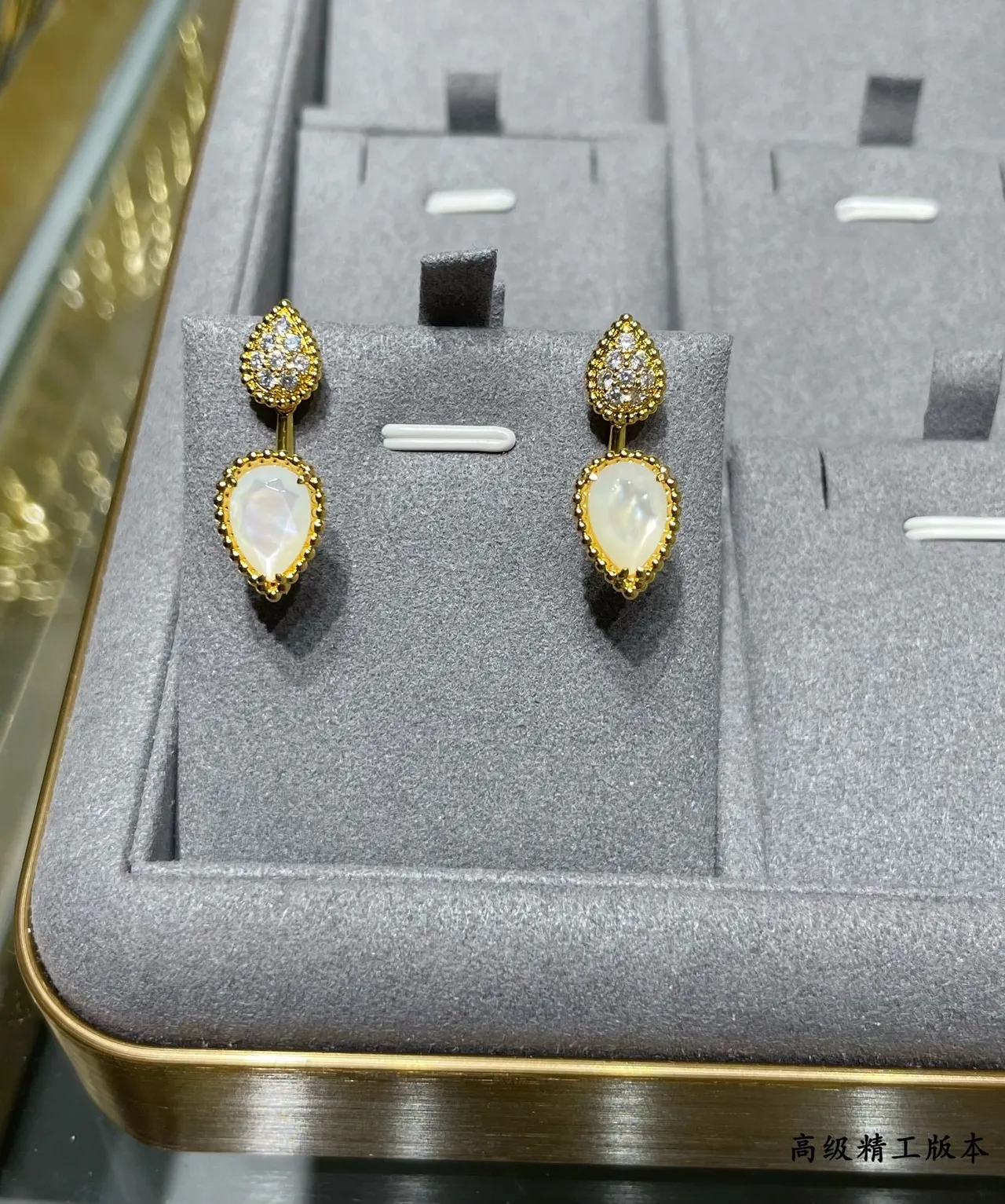 Brincos de gota em tom dourado com forma de gota pavé e pedra branca facetada 6