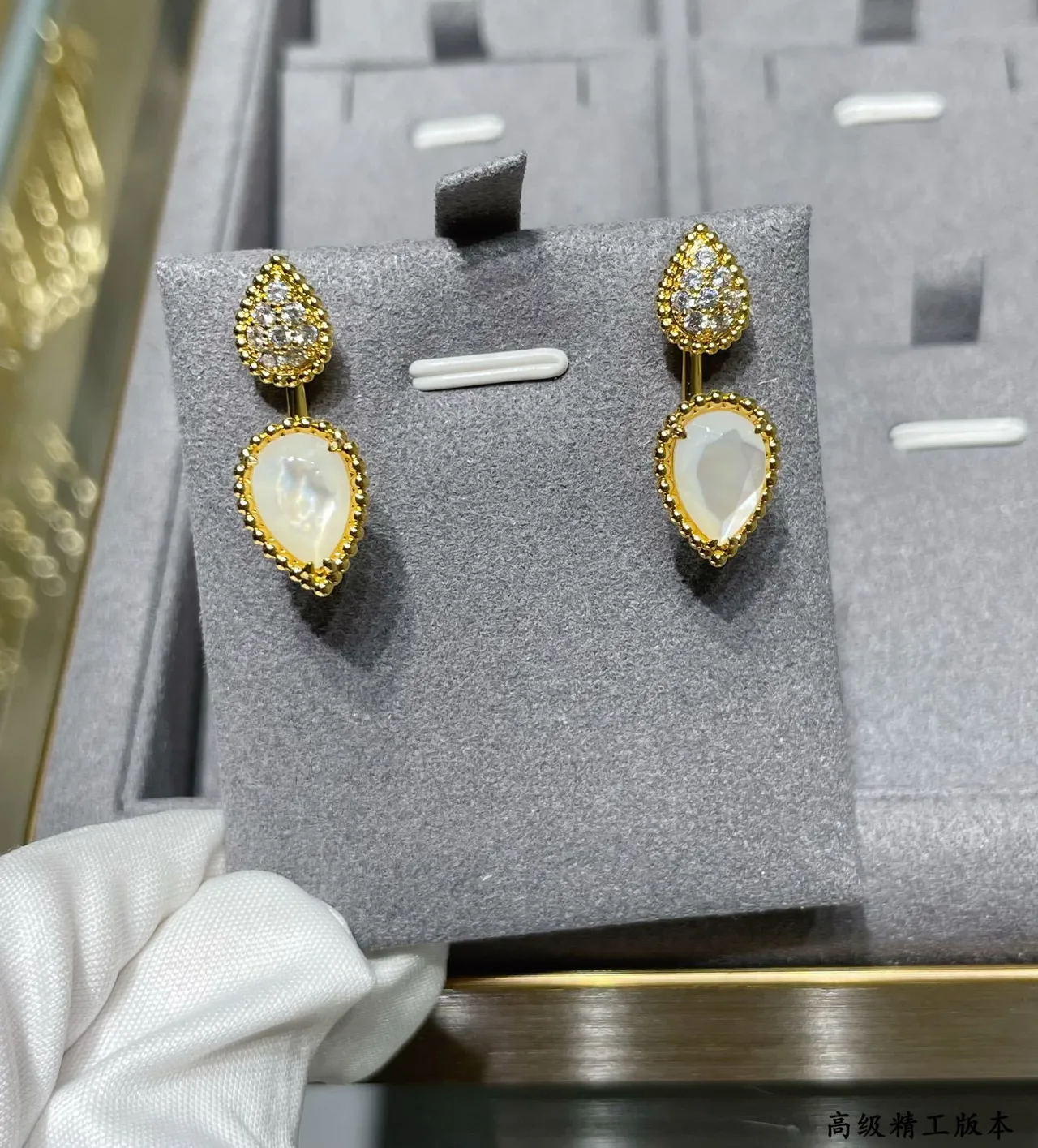 Brincos de gota em tom dourado com forma de gota pavé e pedra branca facetada 7