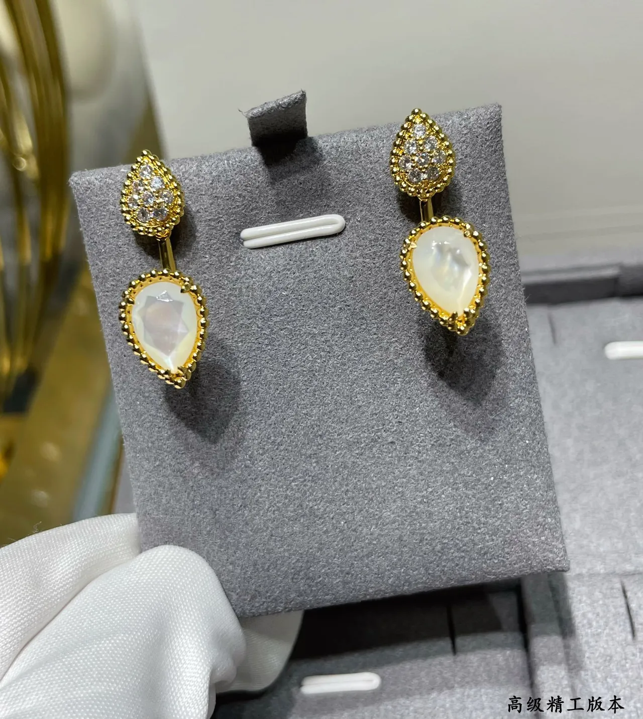 Brincos de gota em tom dourado com forma de gota pavé e pedra branca facetada 8