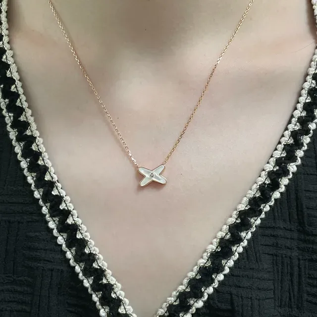 Collar con colgante en forma de X de madreperla y gemas 8