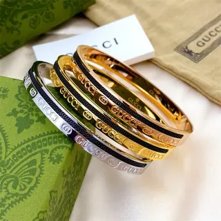 سوار Gucci Logo Bangle ذهبي أسود معدني-نسيجي