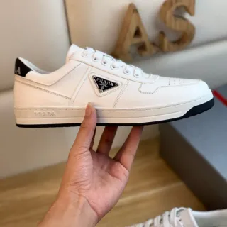 Prada Sneakers Lifestyle Blanc et Noir en Cuir Panelé avec Plaque de Logo Métal Triangulaire