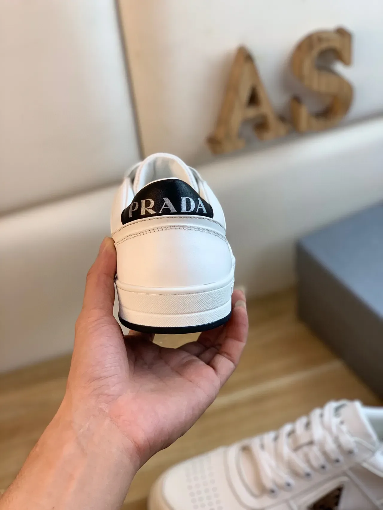 Prada Sneakers Lifestyle Blanc et Noir en Cuir Panelé avec Plaque de Logo Métal Triangulaire 3