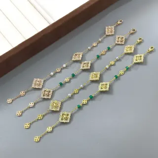 سوار خرزات بيضاء مع تعليقات مربعة مزخرفة ذهبية وخضراء متناوبة