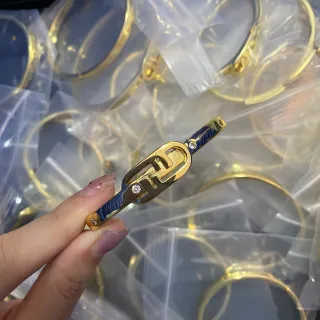 Brazalete de tono dorado esmaltado en azul con acento de cristal