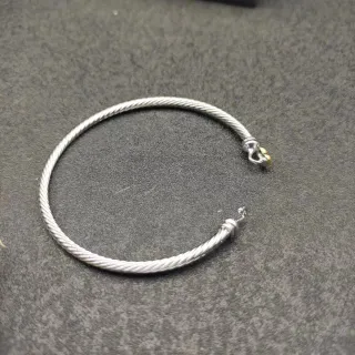 Pulsera de metal con construcción de cable trenzado en plata y oro