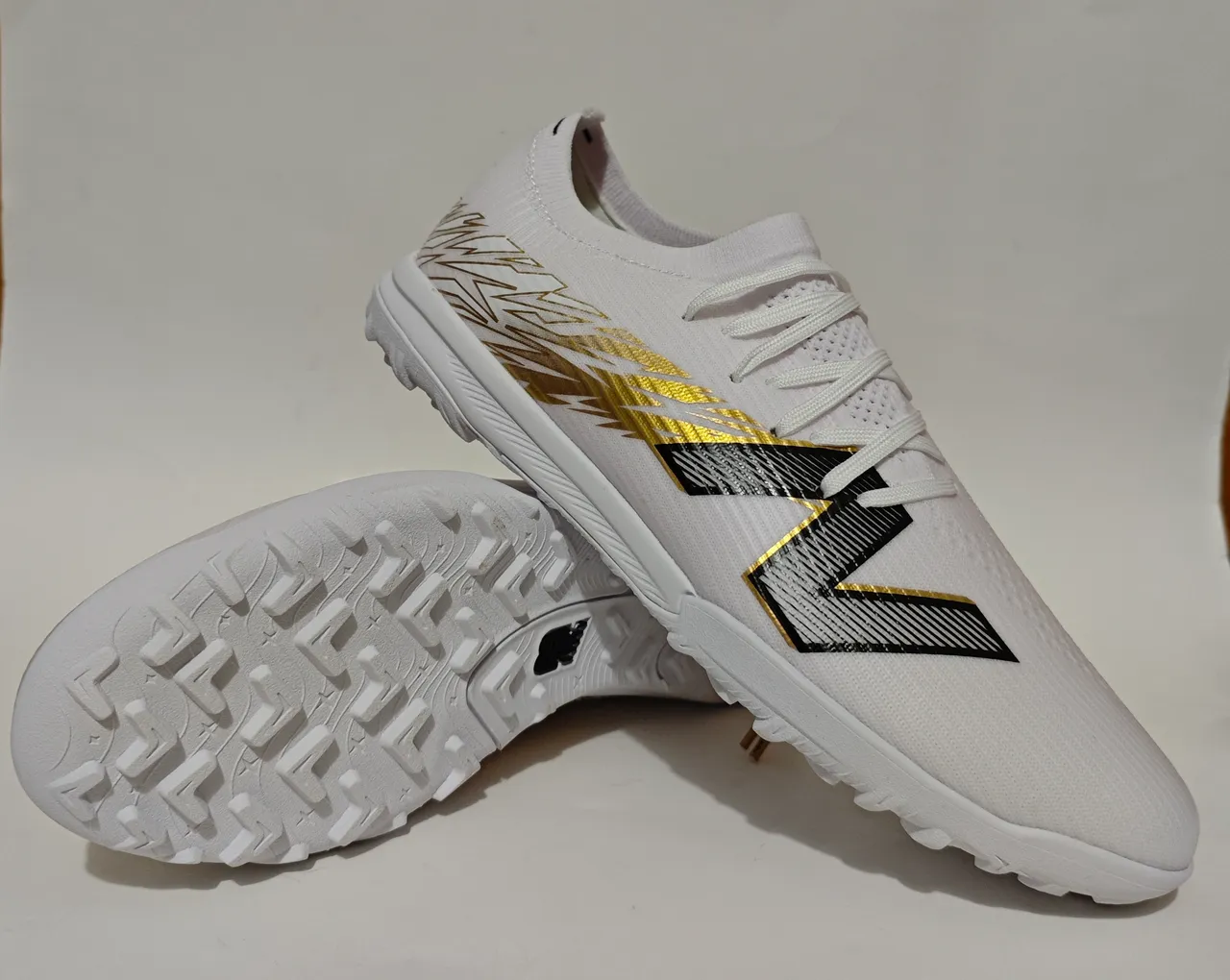 New Balance Chaussures de football pour pelouse artificielle avec upper tricoté blanc doré, overlay de cage synthétique 11