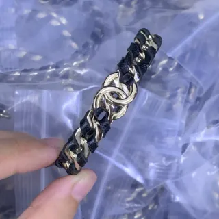 Cadena de tono dorado y pulsera de cuero negro trenzada