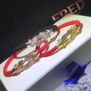 Pulsera con cordón rojo y dorado enrollada con hebilla de nudo