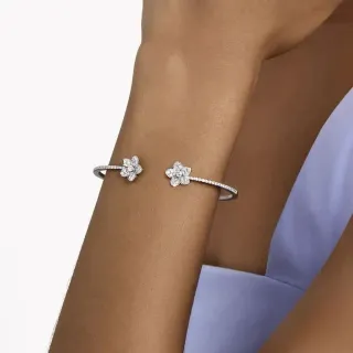 Pulseira de pulso aberta em tom prateado com pavê floral de dupla flor