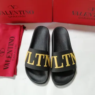 Valentino VLTN Zapatillas deslizantes negras y doradas