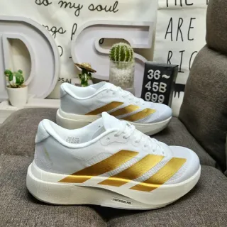 Adidas Chaussures de course blanches et dorées à trois rayures