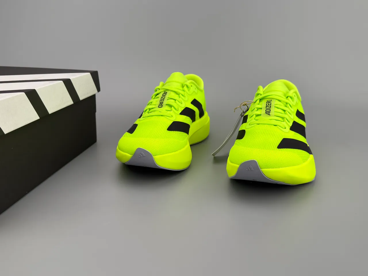 Adidas Tênis de corrida com parte superior em knit neon amarelo preto, branding de três listras 3