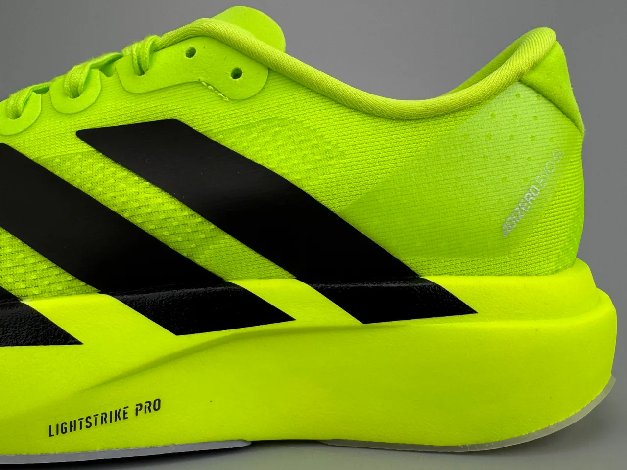 Adidas Tênis de corrida com parte superior em knit neon amarelo preto, branding de três listras 7