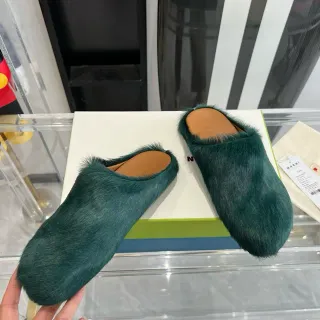 Zapatilla de peluche de color verde turquesa con espalda abierta