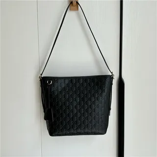 Gucci GG Marmont Sac seau à texture matelassée noire avec monogramme embossé en or 24